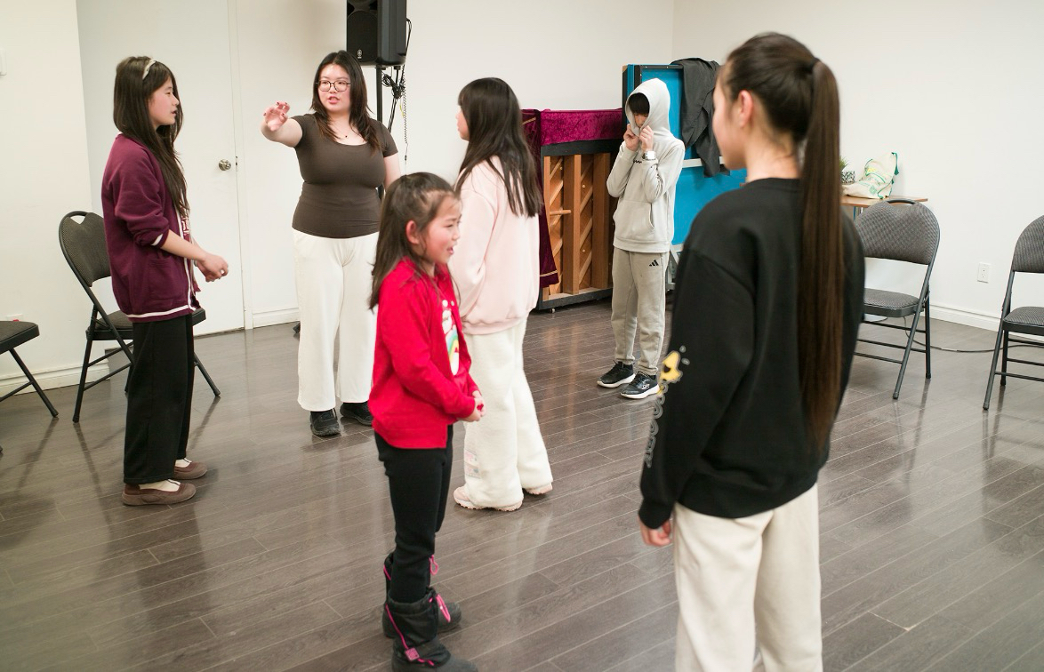 Emily and participants exploring a group theatre activity.